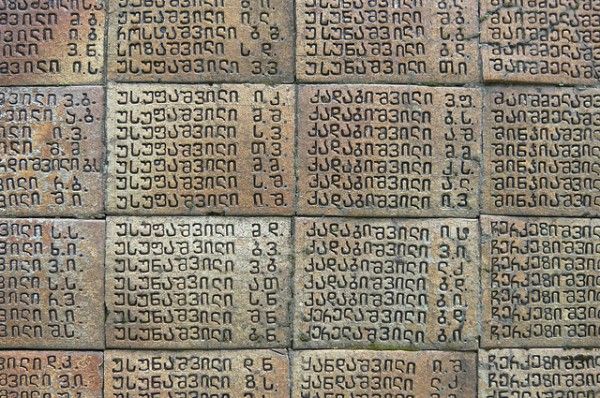 an old brick wall with many different writing on the bricks, including numbers and letters