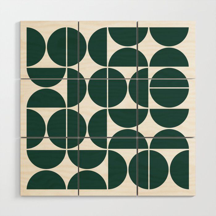 a wooden block with circles and lines in green on the front, against a white wall