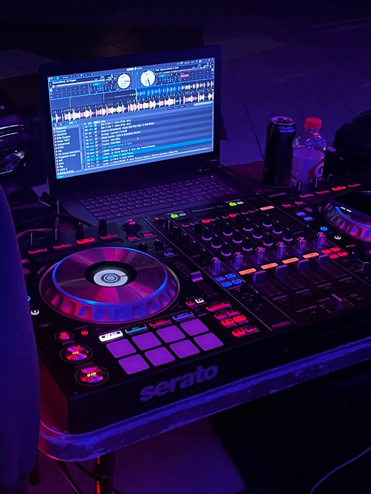 a laptop computer sitting on top of a dj's desk