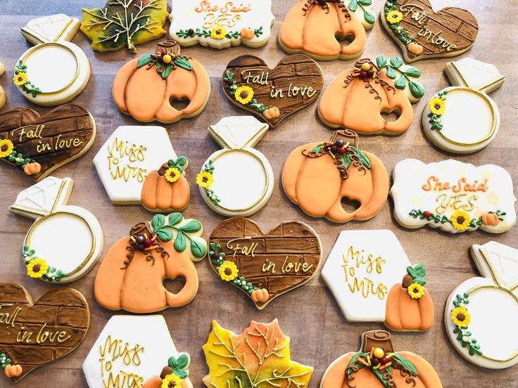 many decorated cookies on a table with leaves and pumpkins in the middle one is for fall