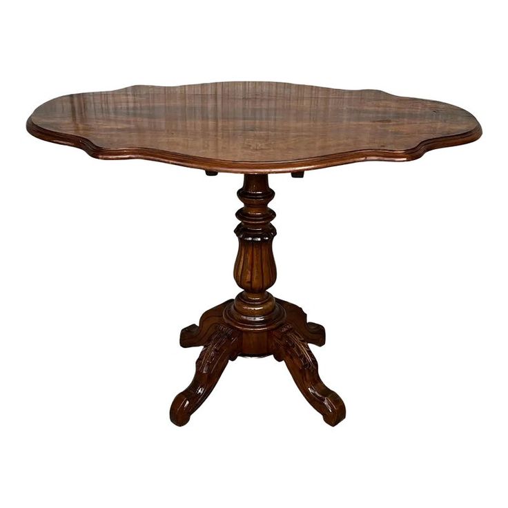 a wooden table with an oval top and pedestals on the legs, against a white background