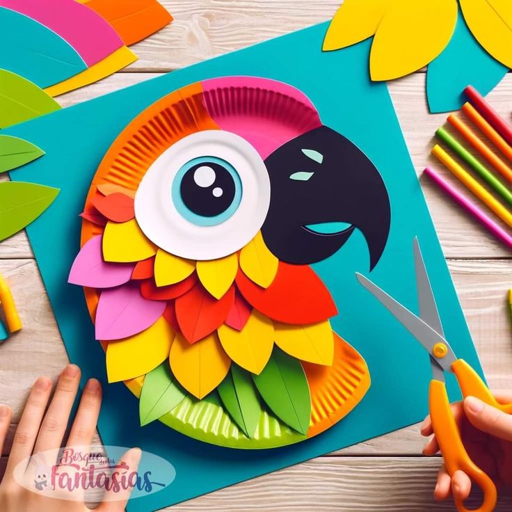 paper plate bird craft with scissors and colored crayons on the table next to it