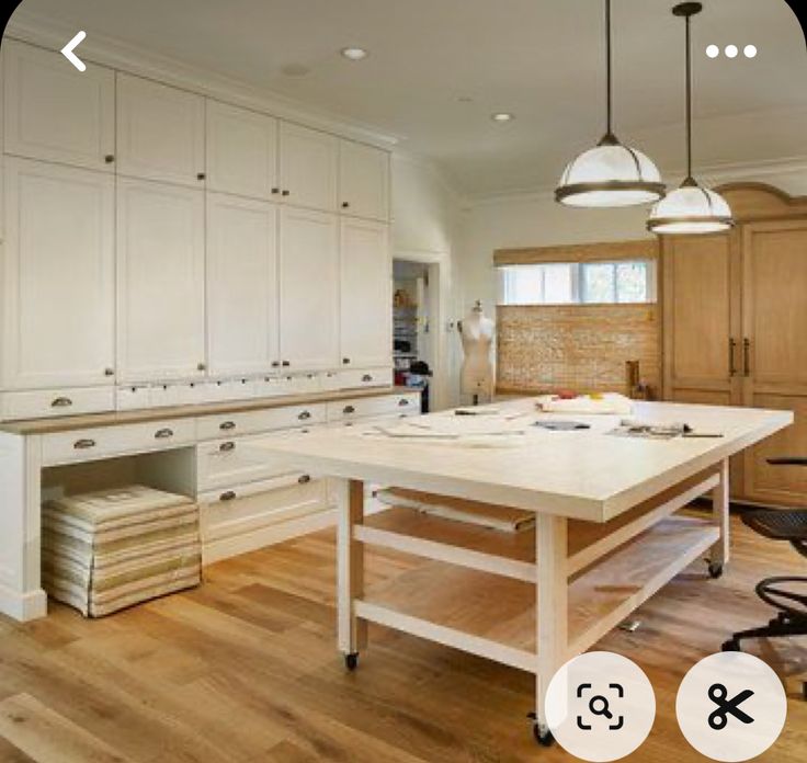 a kitchen with white cabinets and an island in front of the countertop is shown