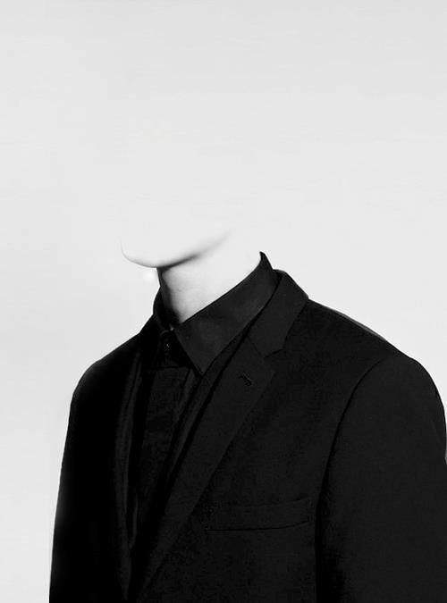 a black and white photo of a mannequin's head wearing a suit