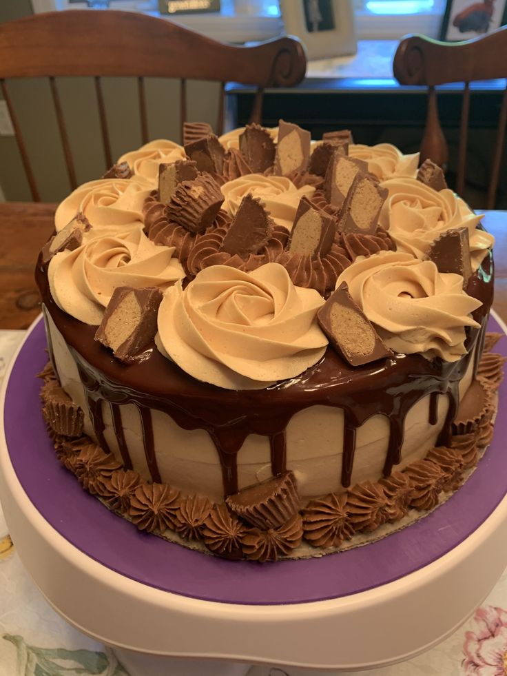 a cake with chocolate icing and white frosting on a purple plate sitting on a table