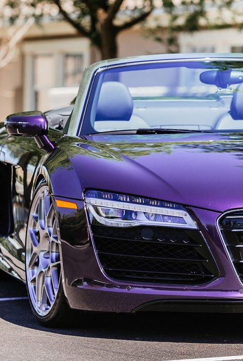 a purple sports car is parked on the street