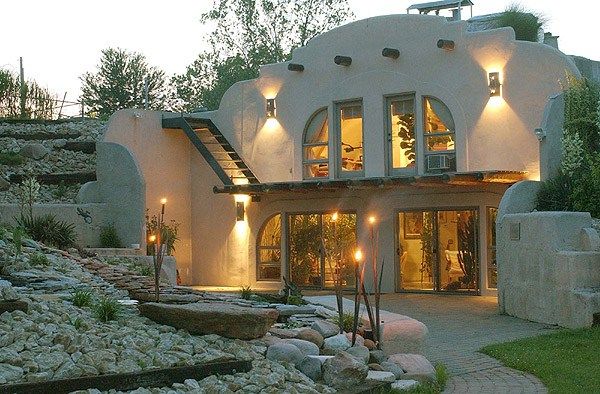 a house that is lit up at night with lights on the windows and steps leading to it