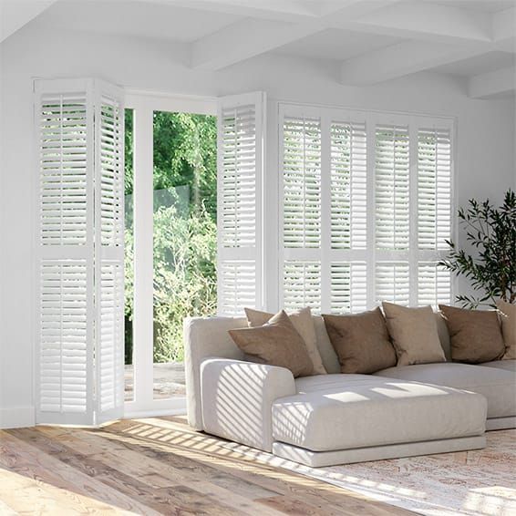 a living room filled with furniture and white shutters