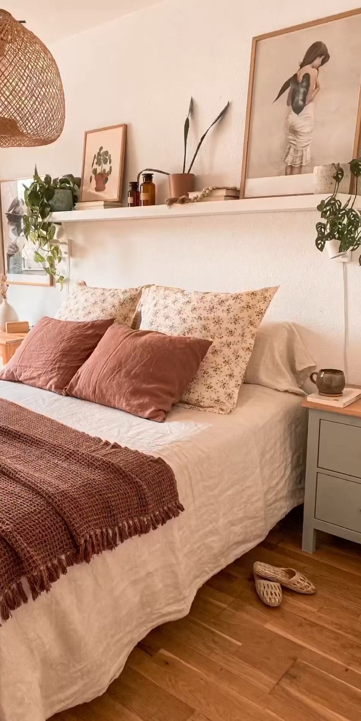 a bed sitting in a bedroom next to a window with plants on top of it