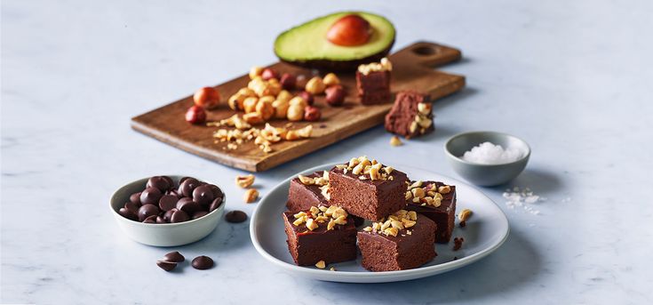 chocolate cake with nuts and avocado on the side, surrounded by other ingredients