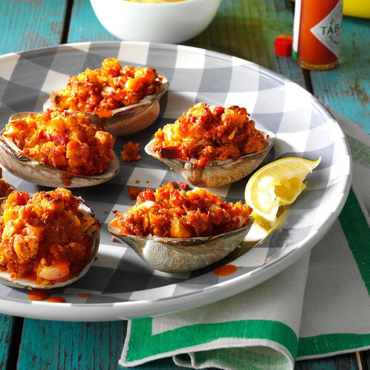 several open oysters are on a plate with lemon wedges and ketchup