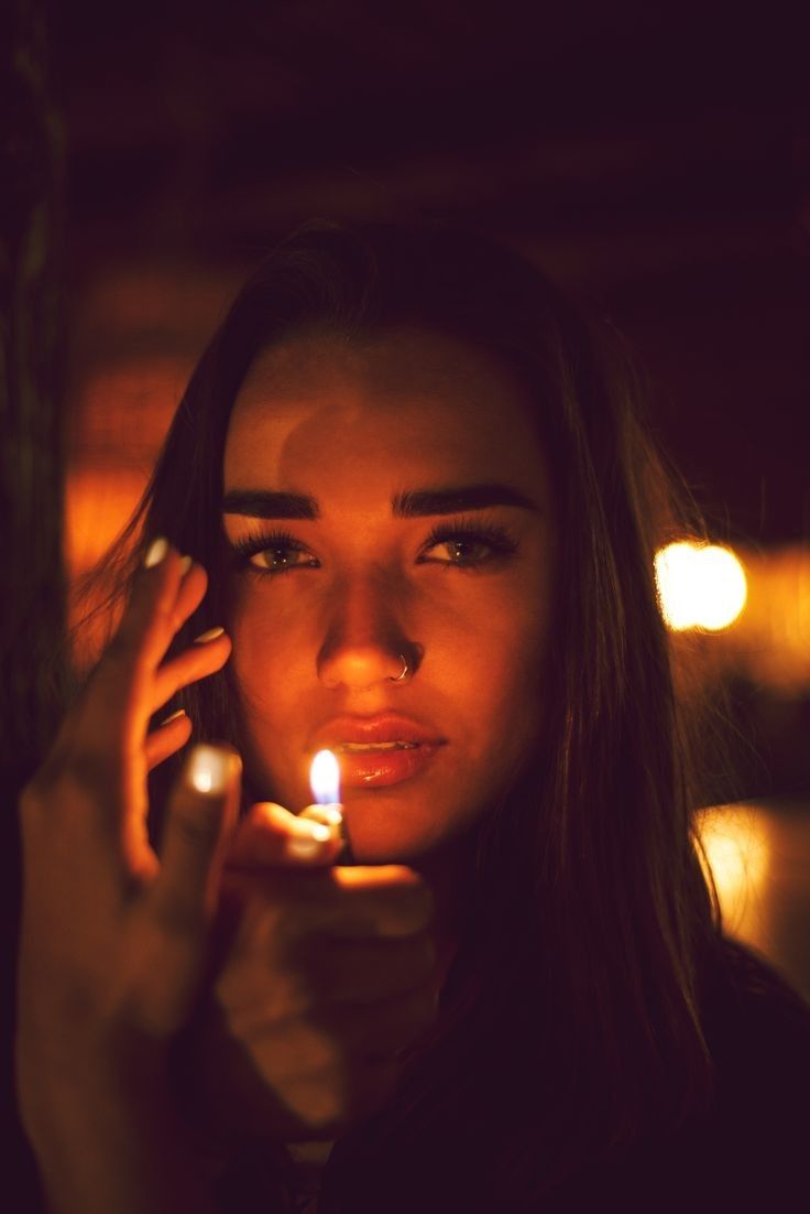 a woman holding a lit candle in her hand