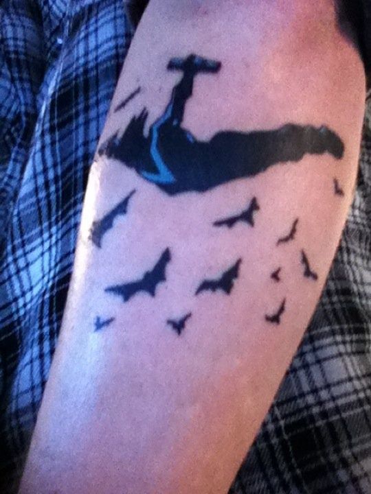 a man with a tattoo on his arm that has birds flying over him and in the water