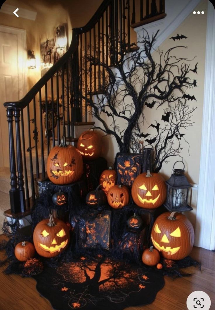 a bunch of pumpkins sitting on top of a table next to a stair case