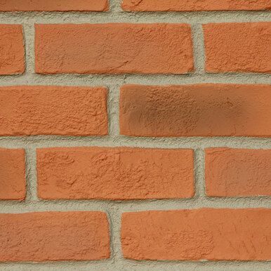 an orange brick wall is shown in this close up shot, with the corner section missing