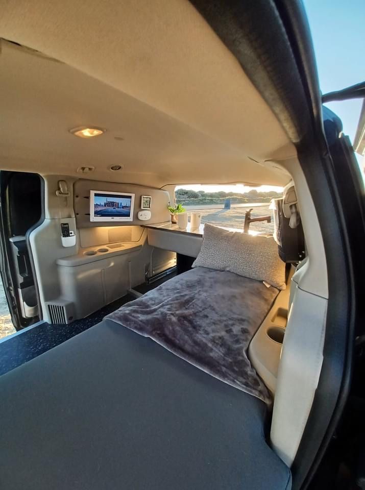 the interior of a vehicle with a bed in it