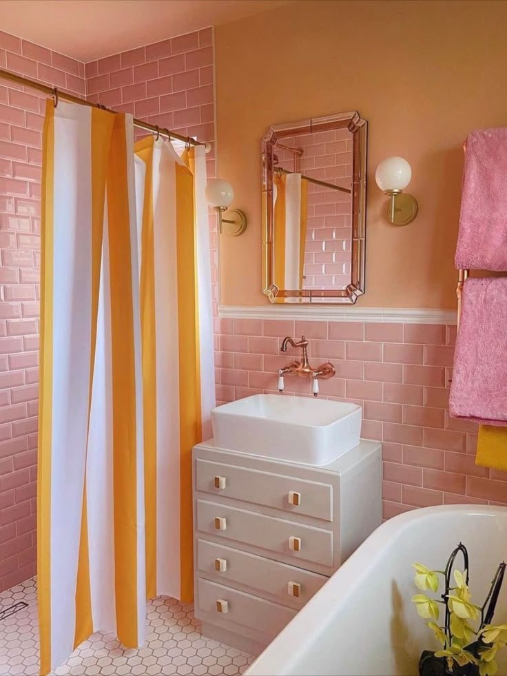 a bathroom with pink and yellow shower curtain, white sink and bathtub in it