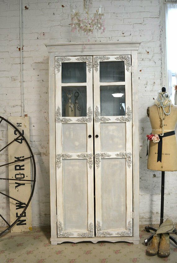 an old white armoire next to a mannequin