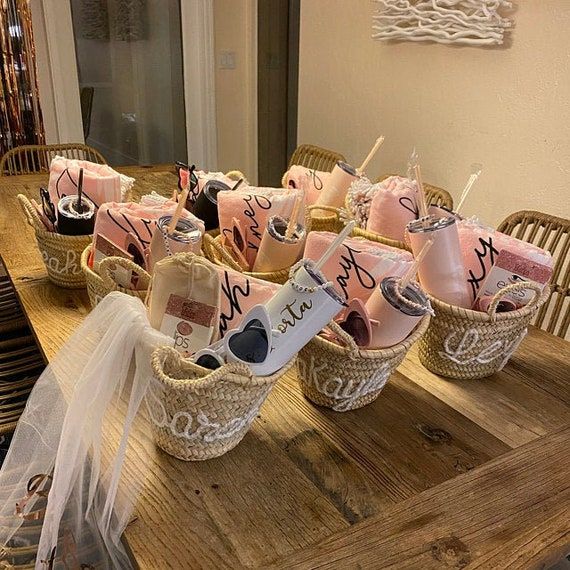 a wooden table topped with baskets filled with pink and white items on top of it