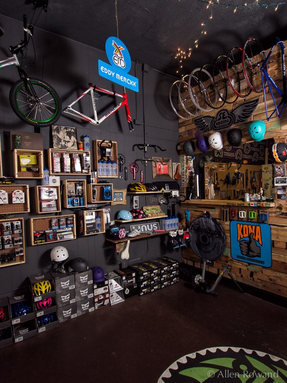 a bike shop with lots of bikes hanging from the ceiling and shelves on the wall