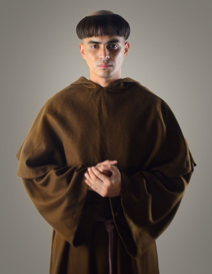 a man dressed in a monk costume posing for a photo with his hands on his chest