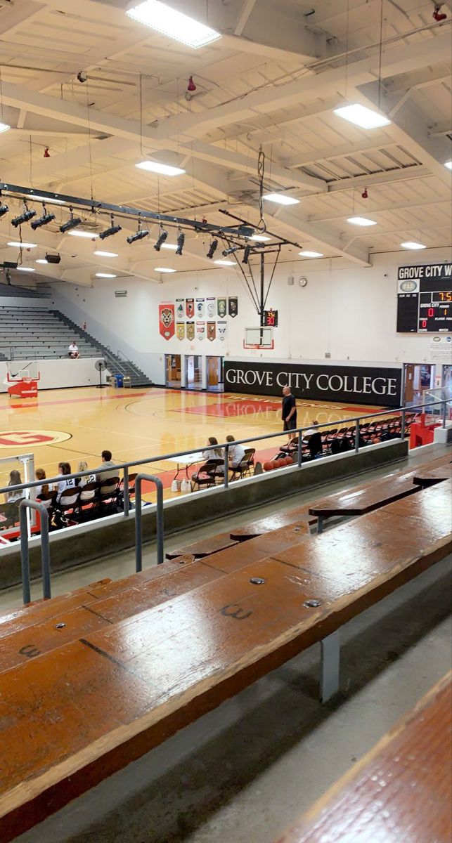 an empty basketball court with benches in the middle