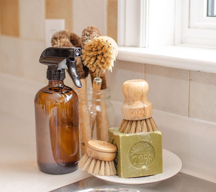 a bathroom sink with soap, brush and soap dispenser sitting on it