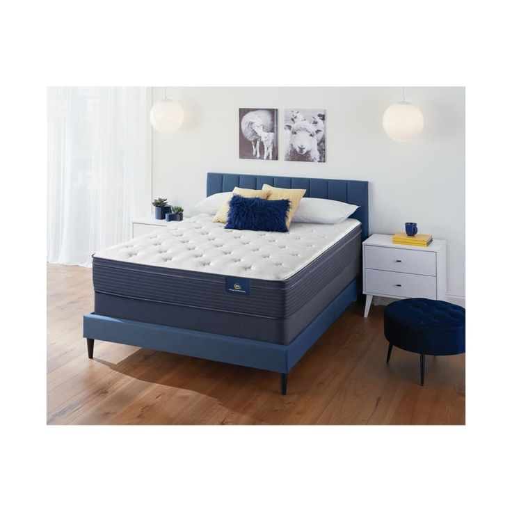 an image of a blue mattress in a white room with wood flooring and furniture