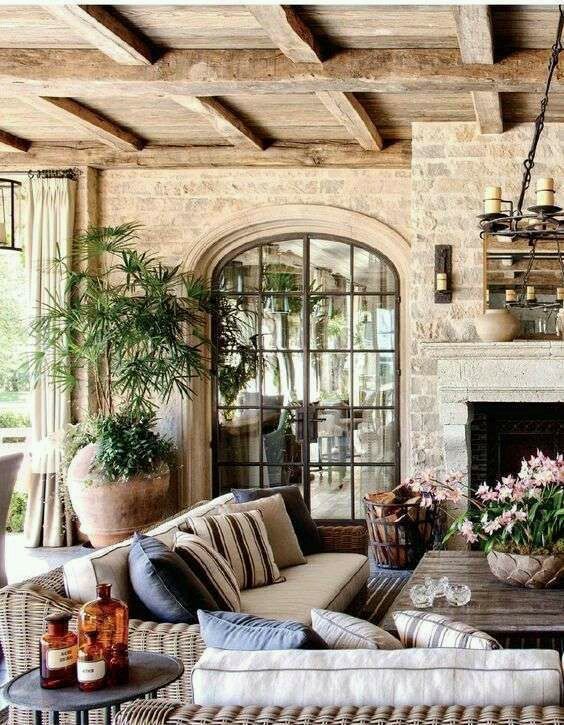 a living room filled with furniture and a fire place next to a fireplace covered in potted plants