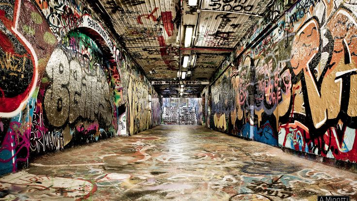 an empty hallway with graffiti all over the walls