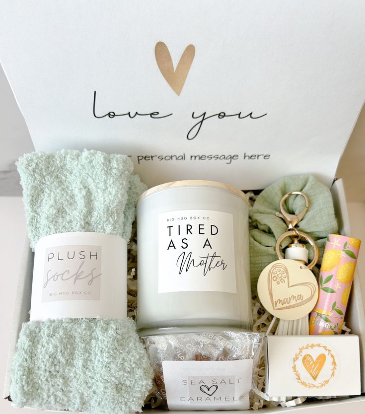 an open box containing personal care items including a candle, tea towel, and more