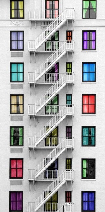 an apartment building with multicolored windows and balconies