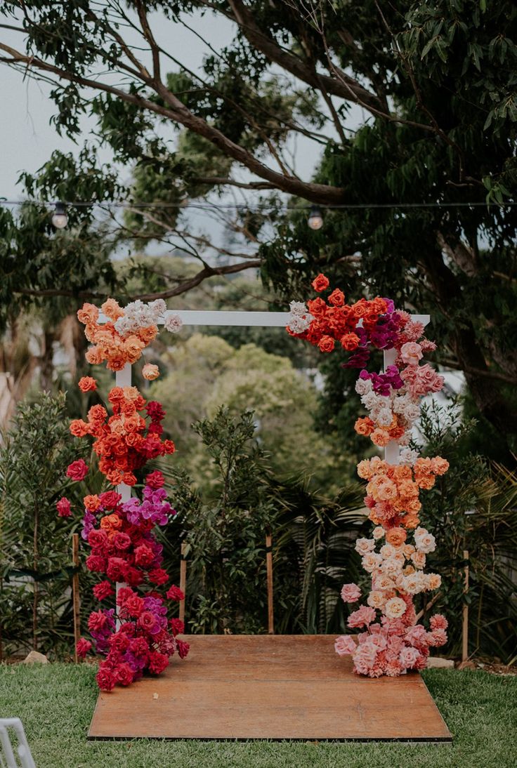 an outdoor ceremony setup with flowers on the aisle and chairs in the backgroud