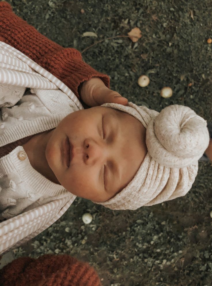 a baby wearing a white hat and sweater