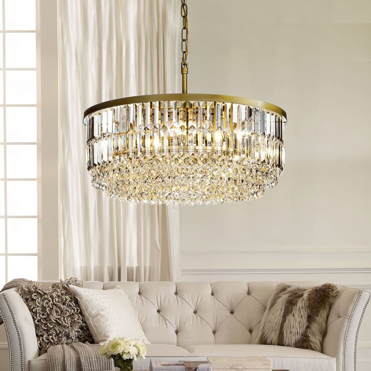 a living room with a couch, coffee table and chandelier