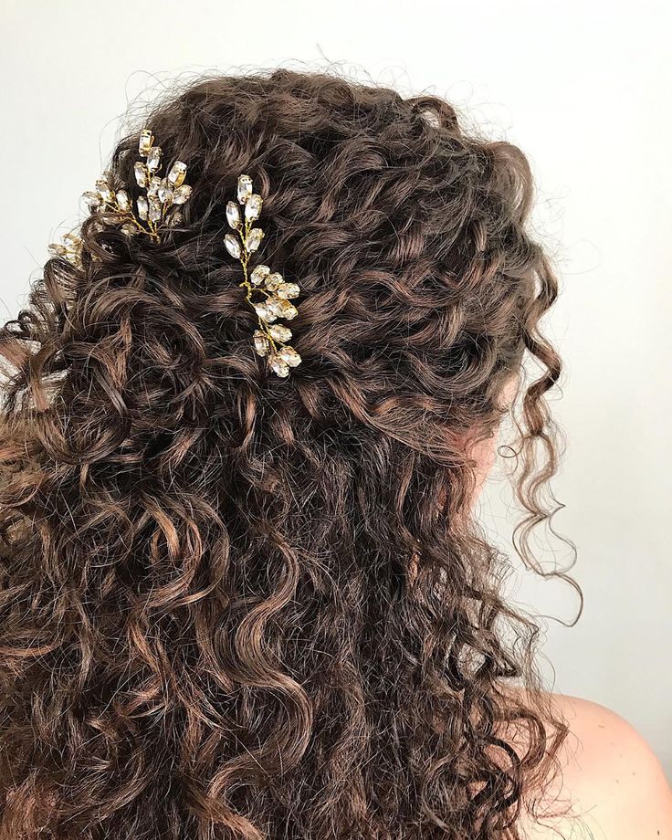 the back of a woman's head with curly hair and gold leaves on it