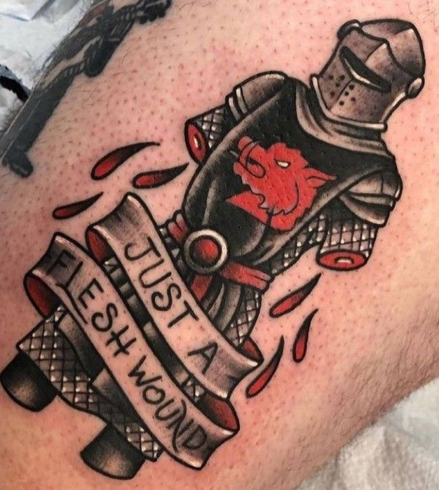 a man with a tattoo on his thigh has an image of a red demon in a gas mask