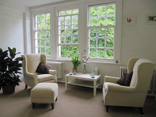 a living room filled with furniture and large windows