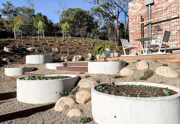 several cement planters in front of a brick building