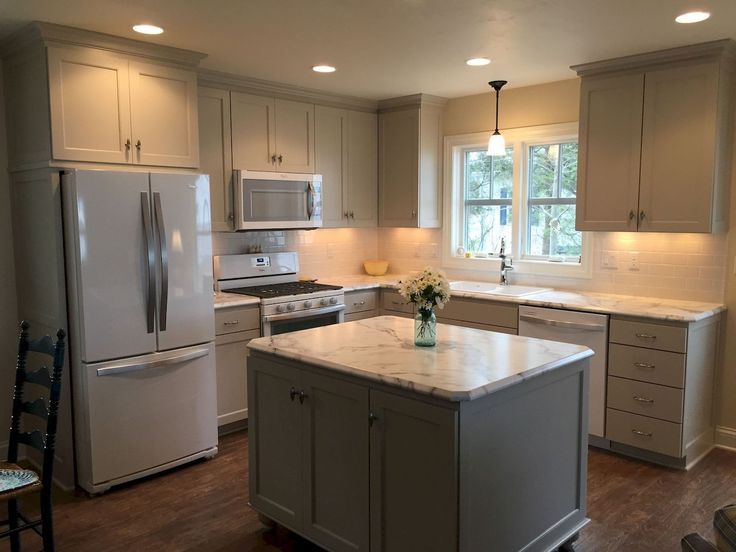 a kitchen with an island, stove and refrigerator