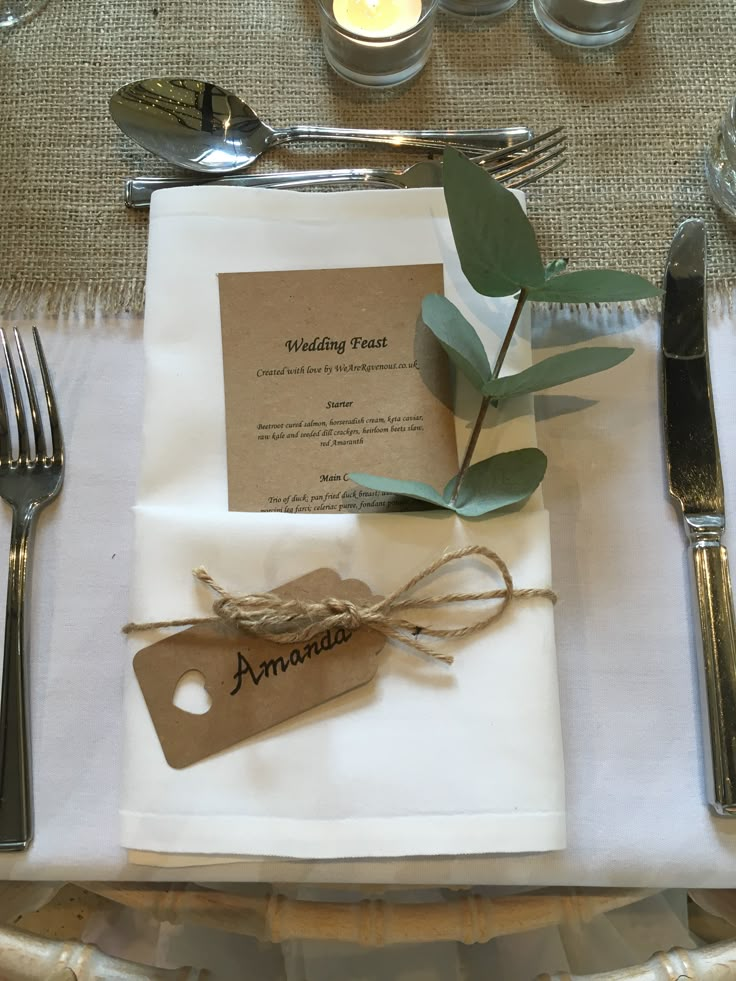 the place setting is set with silverware, napkins, and an olive branch