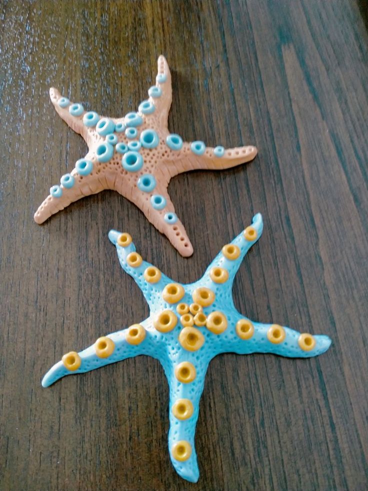 three starfishs sitting on top of a wooden table with blue and yellow decorations