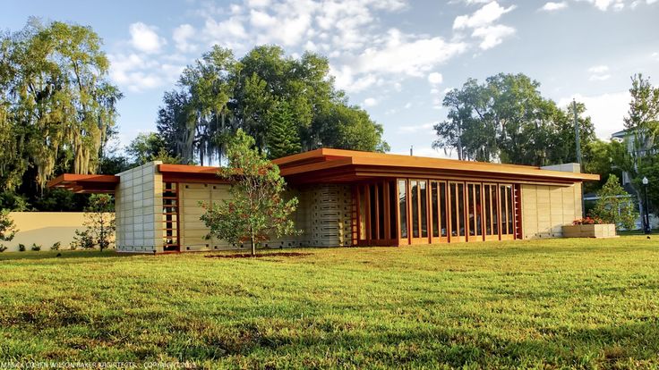 a modern house in the middle of a grassy area