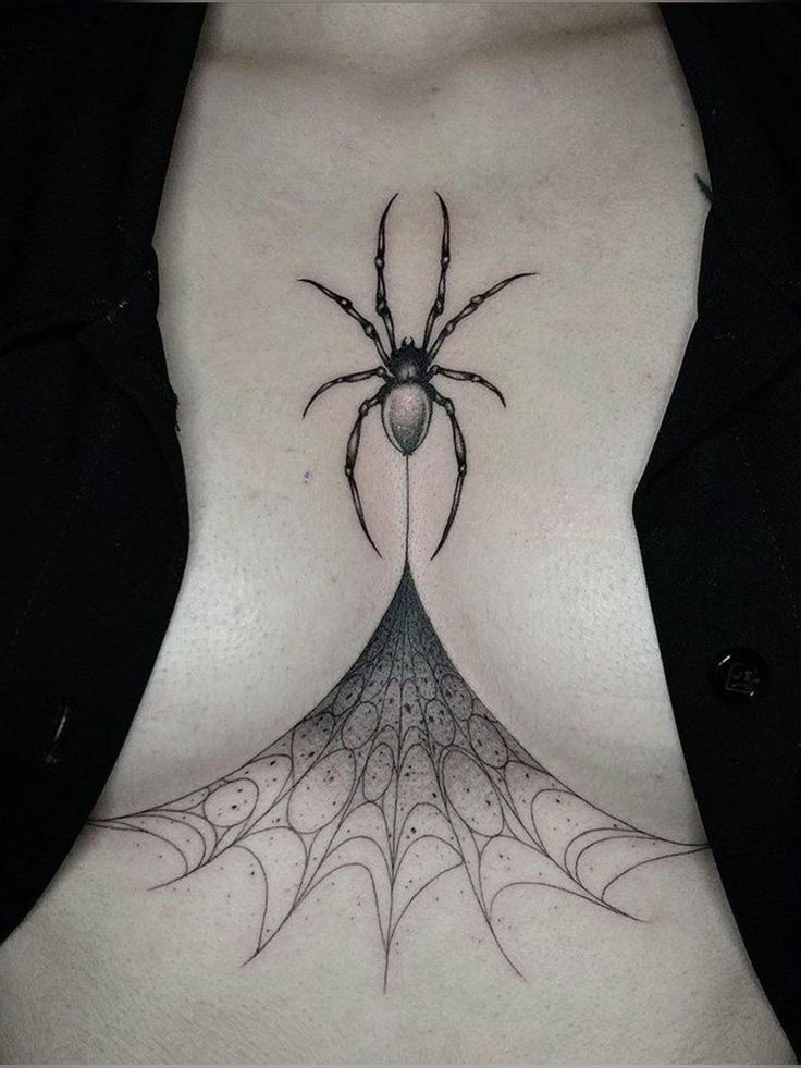 a woman's stomach with a spider tattoo on it