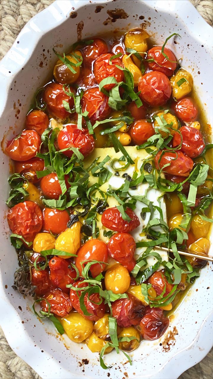 a white bowl filled with tomatoes and greens