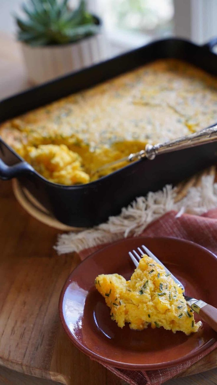 a piece of quiche on a plate with a fork next to the casserole