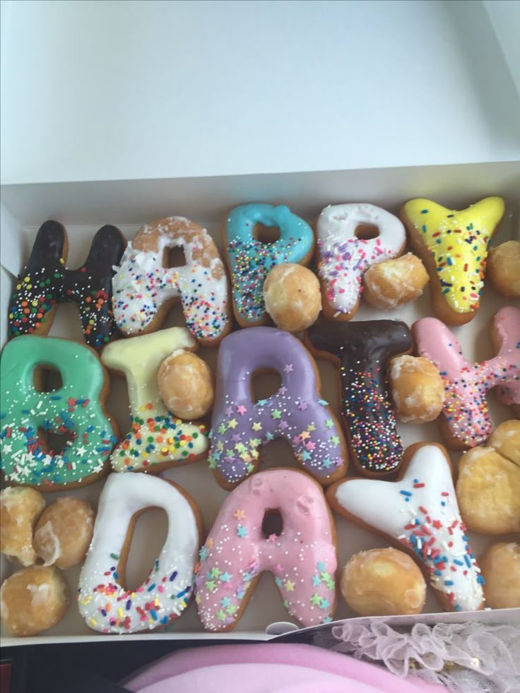 a box filled with lots of donuts covered in sprinkles and frosting