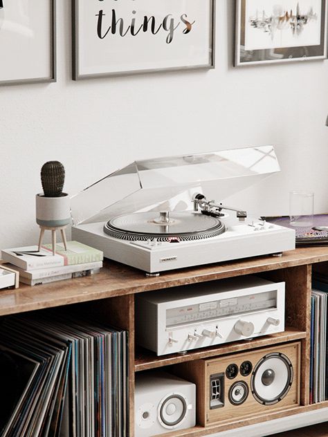 a record player sitting on top of a wooden shelf next to a wall filled with records