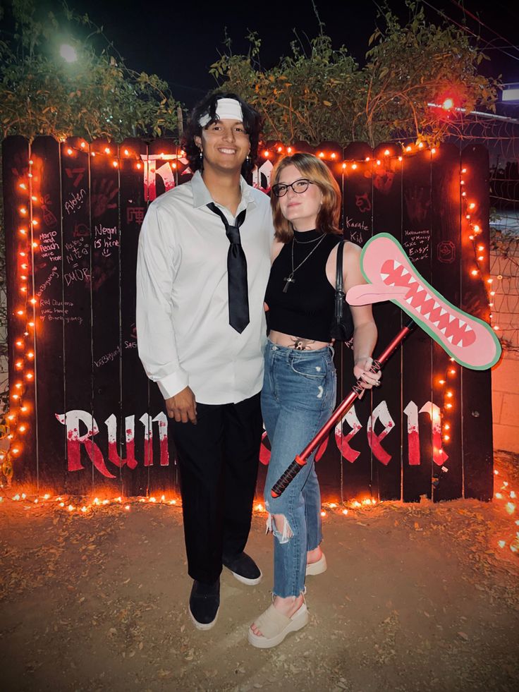 a man and woman standing next to each other in front of a sign with lights