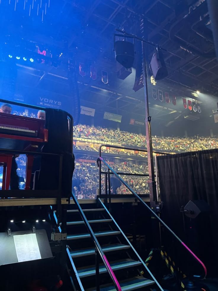 the stage is set up for a concert with people sitting in seats and standing on stairs